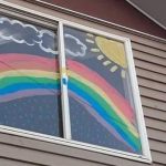 Los niños pintan arcoiris en sus ventanas
