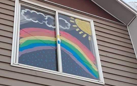 Los niños pintan arcoiris en sus ventanas